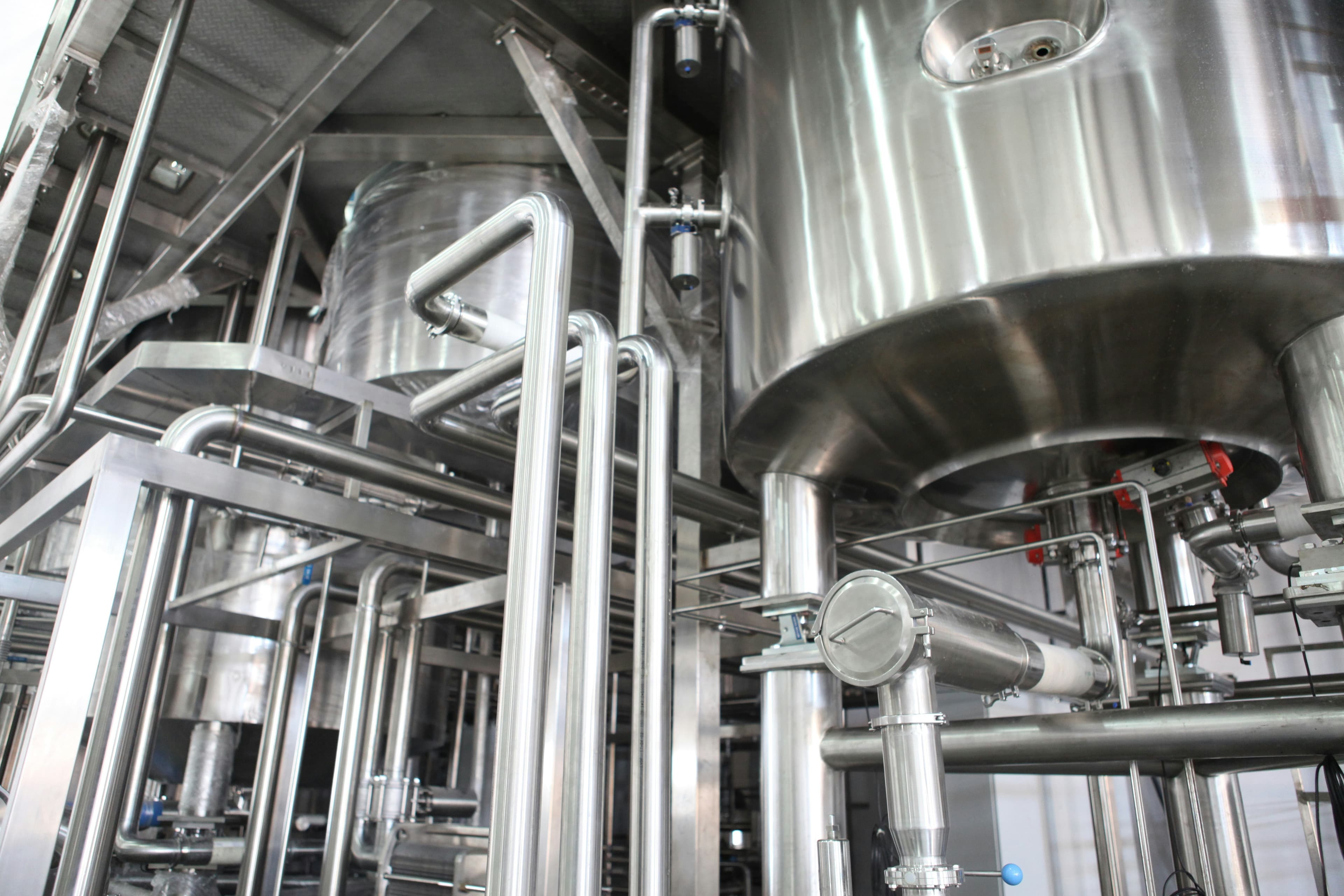 Industrial stainless steel tanks representing systematic work order analysis and bottleneck identification